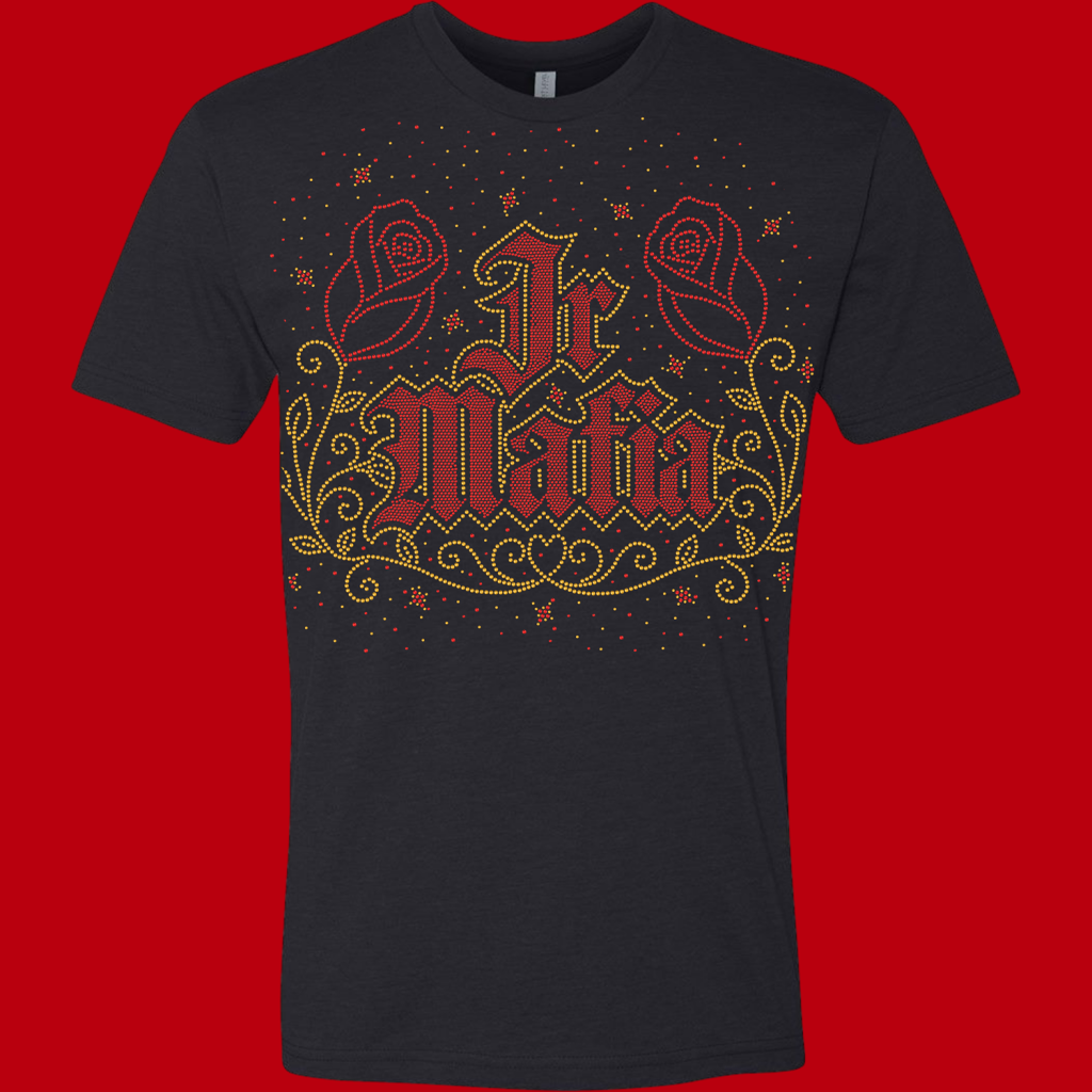 Dark T-shirt with a red-and-gold rhinestone design: two roses on the sides, ornate swirls, and the word 'Glam' in embellished lettering.