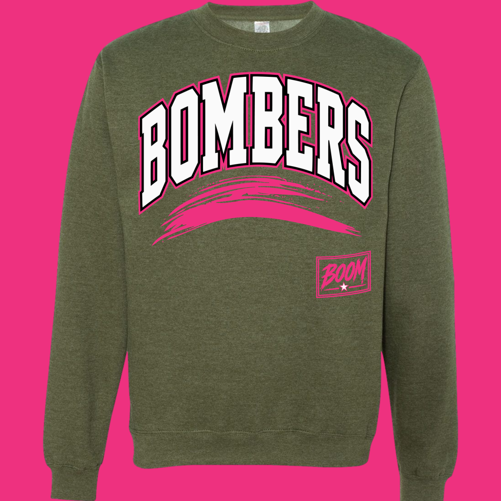 Olive-green sweatshirt with a bold white 'BOMBERS' graphic outlined in pink and a pink brush arc underneath, plus a pink logo on the chest pocket.